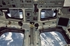 thumbnail to a view of a view from the flight deck of the Space Shuttle, looking to the aft of the craft / vignette-lien vers une vue du pont de travail de la navette spatiale. La vue est en direction de l'arrire de la navette