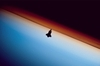 thumbnail to a view of the silhouette of shuttle Endeavour against the Earth's limb prior to the STS-130 mission rendezvous with the ISS, on Flight Day 3. The orange layer which is the troposphere gives way to the whitish stratosphere and then into the mesosphere / vignette-lien vers une vue de la navette Endeavour se silhouettant sur le limbe terrestre (jour de vol n3) avant son rendez-vous avec l'ISS. La couche orange est la troposphre, qui laisse la place  la stratosphre puis  la msosphre