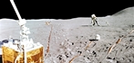 thumbnail to a view of a panorama which combines two photographs taken by Apollo 15 lunar module pilot Jim Irwin, at the end of the second Apollo 15 moonwalk on August 1, 1971. It shows the Apollo Lunar Surface Experiments Package (ALSEP) site in the foreground as the Passive Seismic Experiment is seen beyond the left side. The Lunar Surface magnetometer lies in the background near the center as mission commander David R. Scott is leaning to his right and putting down the Apollo Lunar Surface drill used to take core samples and set up a heat flow experiment. The Solar Wind Spectrometer further is in the right foreground