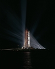 vignette-lien vers une vue de projecteurs dans la nuit qui illuminent la mission Apollo 8 au pas de tir 39-A du Kennedy 
Space Center. Cette mission fut le premier vol habit lanc par la fuse Saturn V