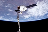 vue du vaisseau-cargo commercial Dragon arrim par le bras Canadarm2 de l'ISS. Ce vol, en mai 2012, reprsente le premier vol commercial jamais ralis  la Station Spatiale